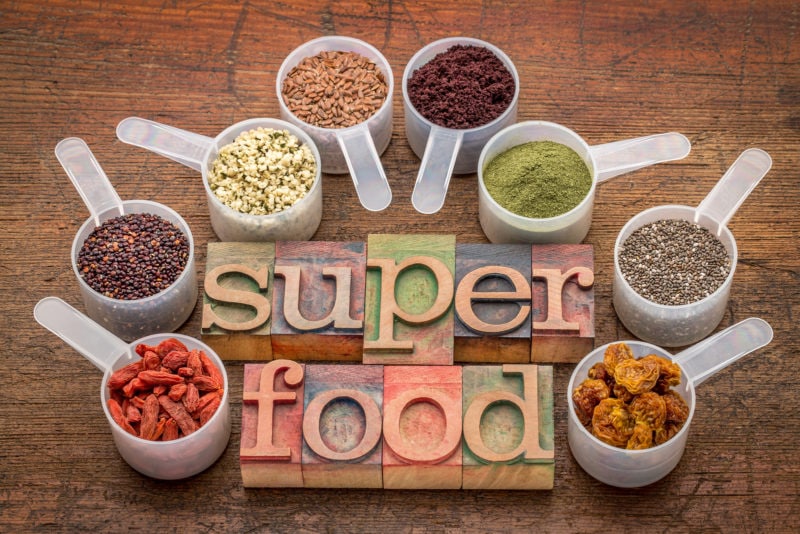 various superfoods on wooden table