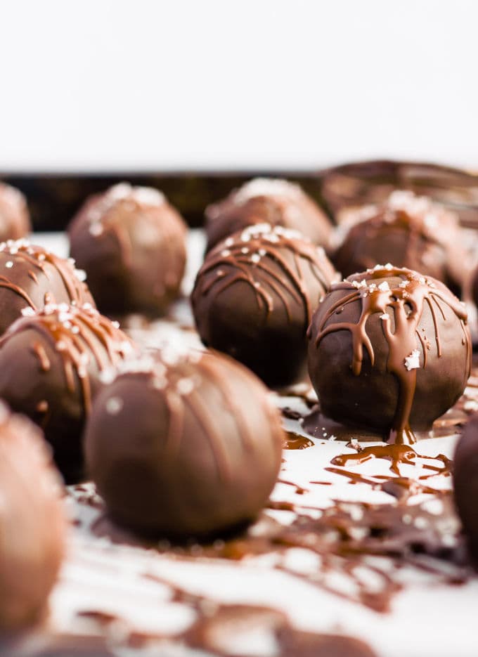 These chocolate covered protein bounty balls are a healthy, homemade version of the classic candy bar. Made of only 6 simple ingredients, these easy to make protein balls are the perfect post-workout treat. This no-bake recipe is also paleo, vegan, gluten-free, flourless, dairy-free and… guilt-free! | www.onecleverchef.com #paleo #vegan #glutenfree #postworkout #protein #healthy #treat #cleaneating