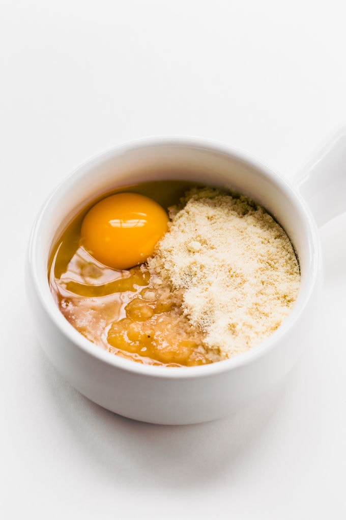 An egg, blanched almond flour and mashed banana in a mug.
