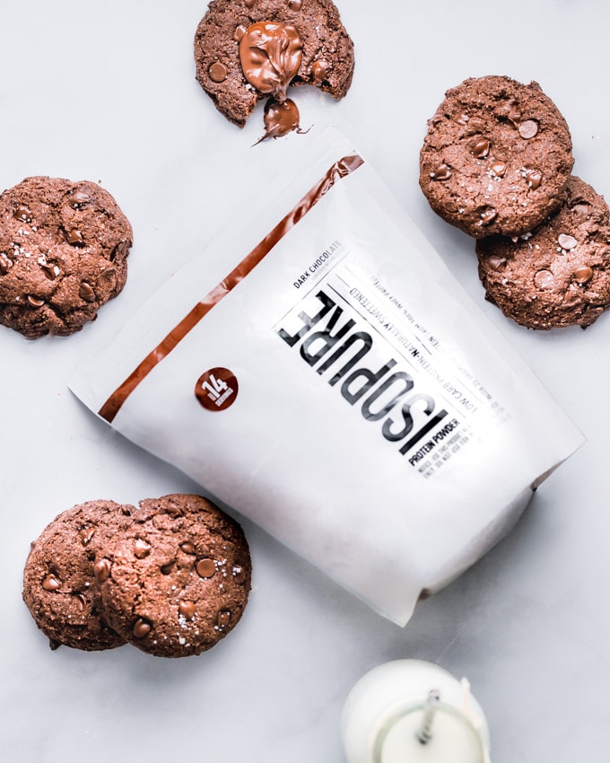 Double chocolate protein cookies, placed around a protein powder bag